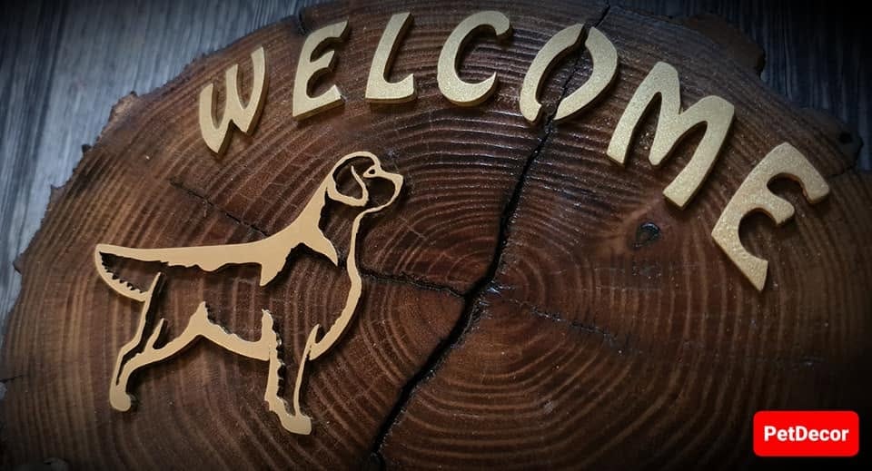 Close-up of the brass Golden Retriever silhouette, Welcome lettering and acacia grain