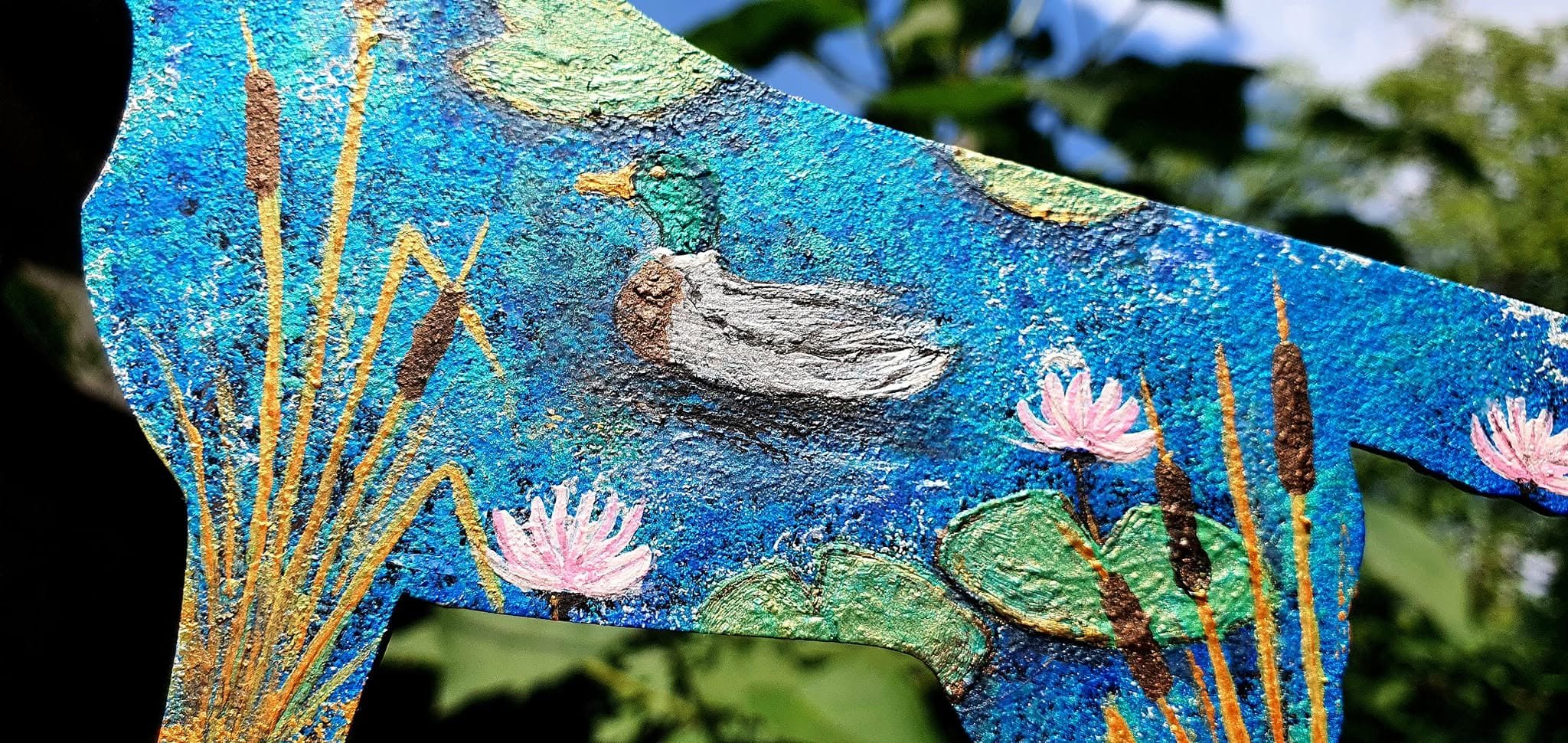 Detail of blue painting with a duck, reeds and water lilies in daylight