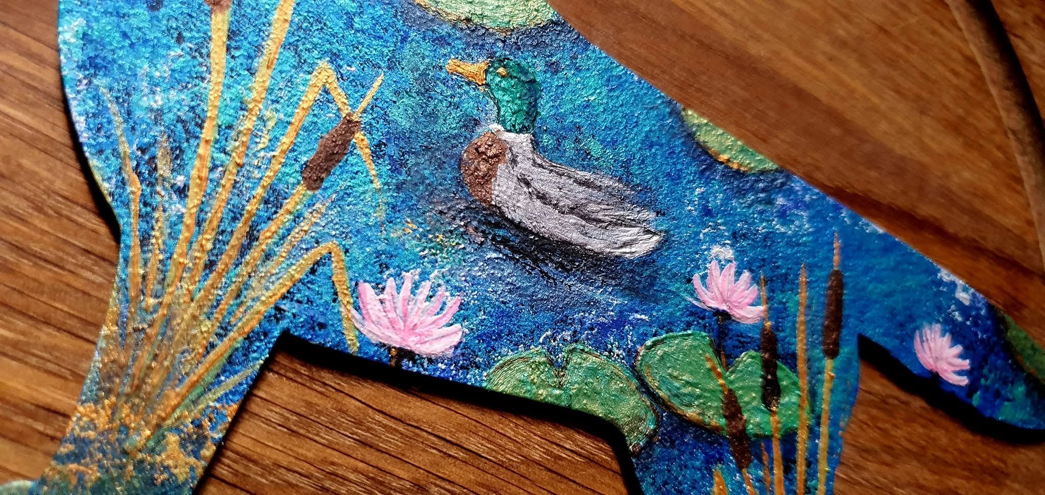 Hand-painted texture with a duck and water lilies on a blue dog silhouette