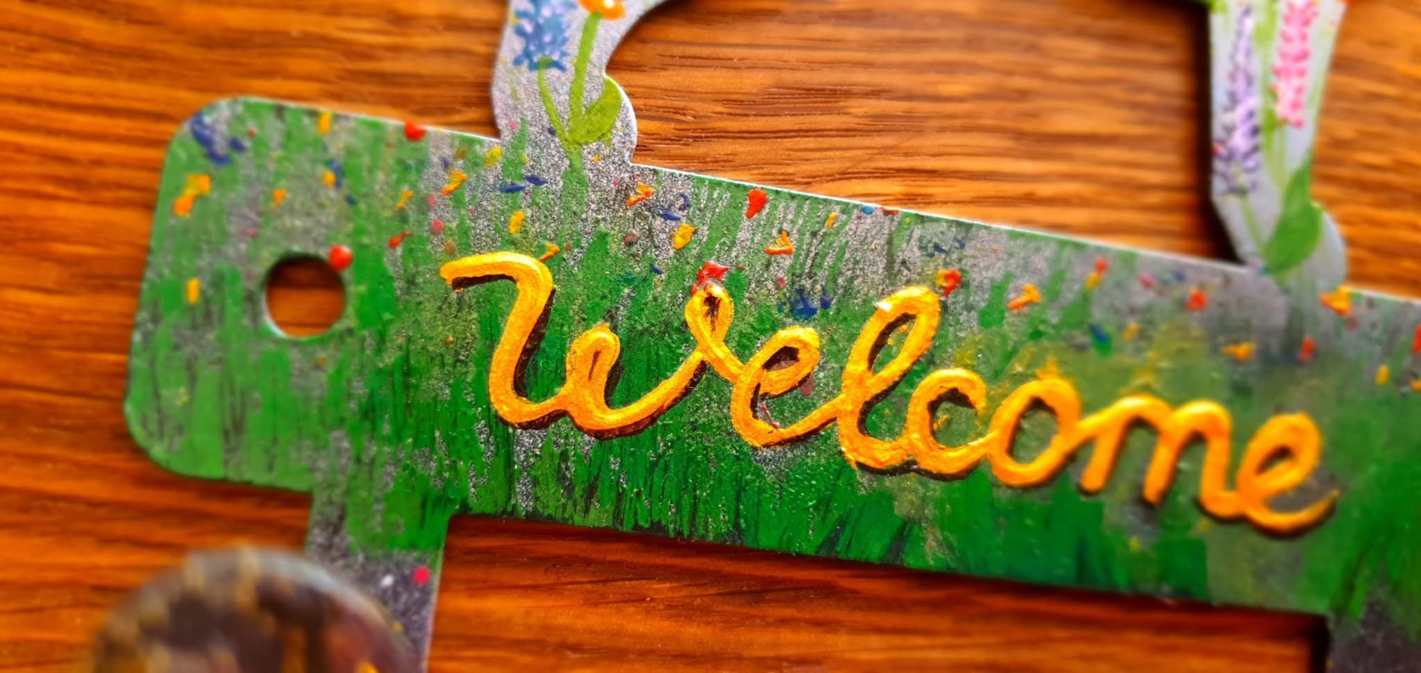Close-up of the hand-painted green hanger bar with Welcome lettering