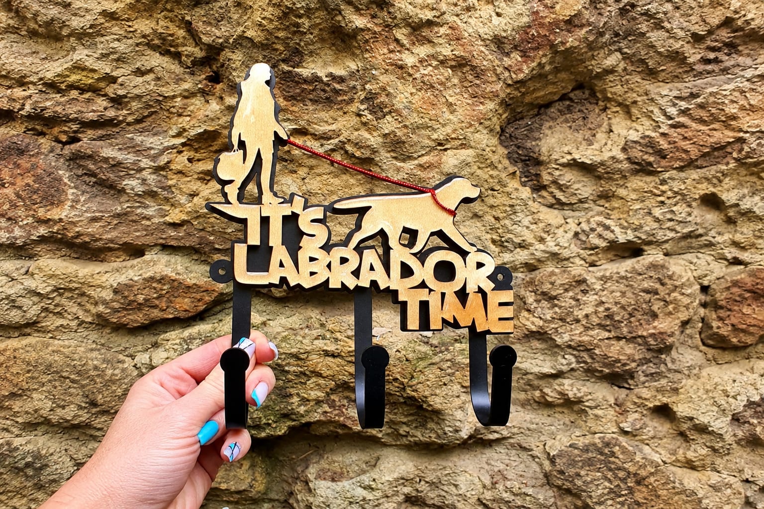 Ключница «It’s Labrador Time» в руке на фоне каменной стены