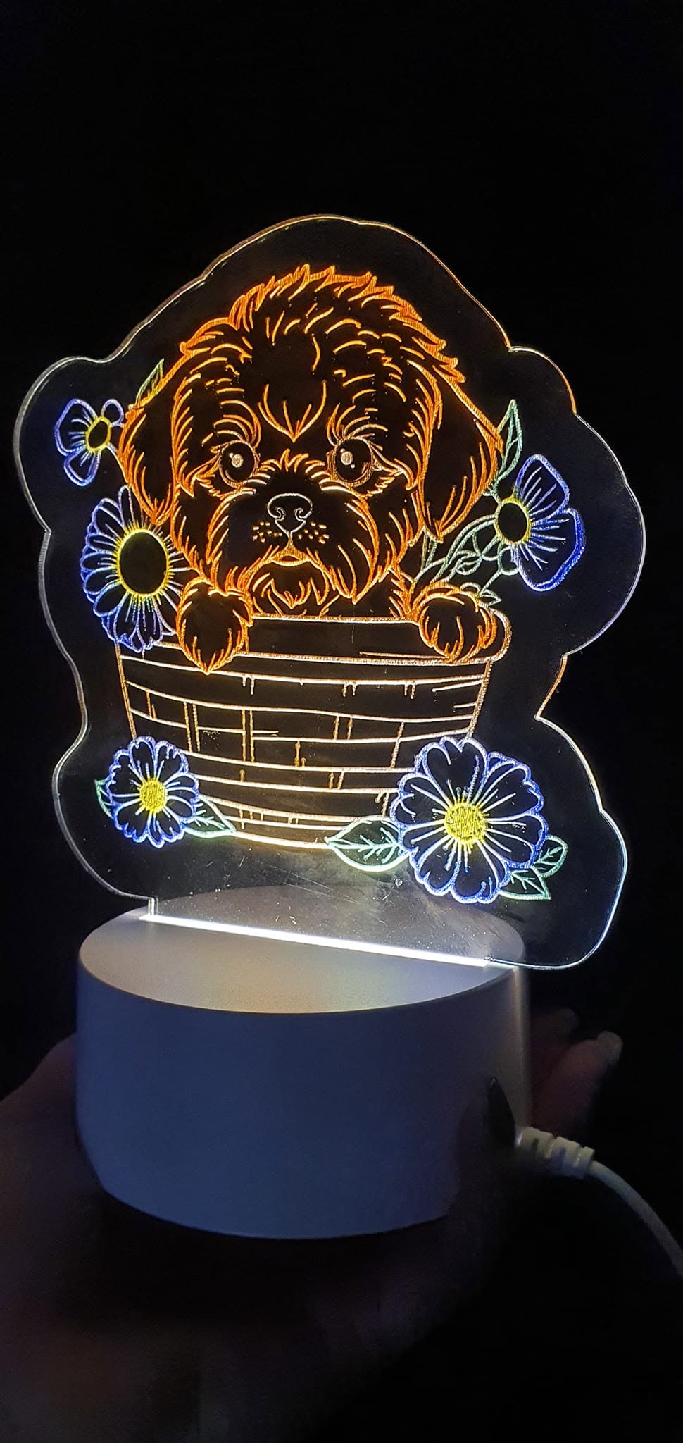 Night light with a coloured puppy design in a basket among flowers