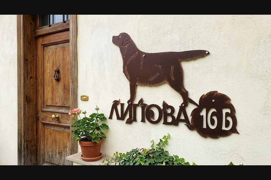 Адресная табличка с лабрадором на стене у входа